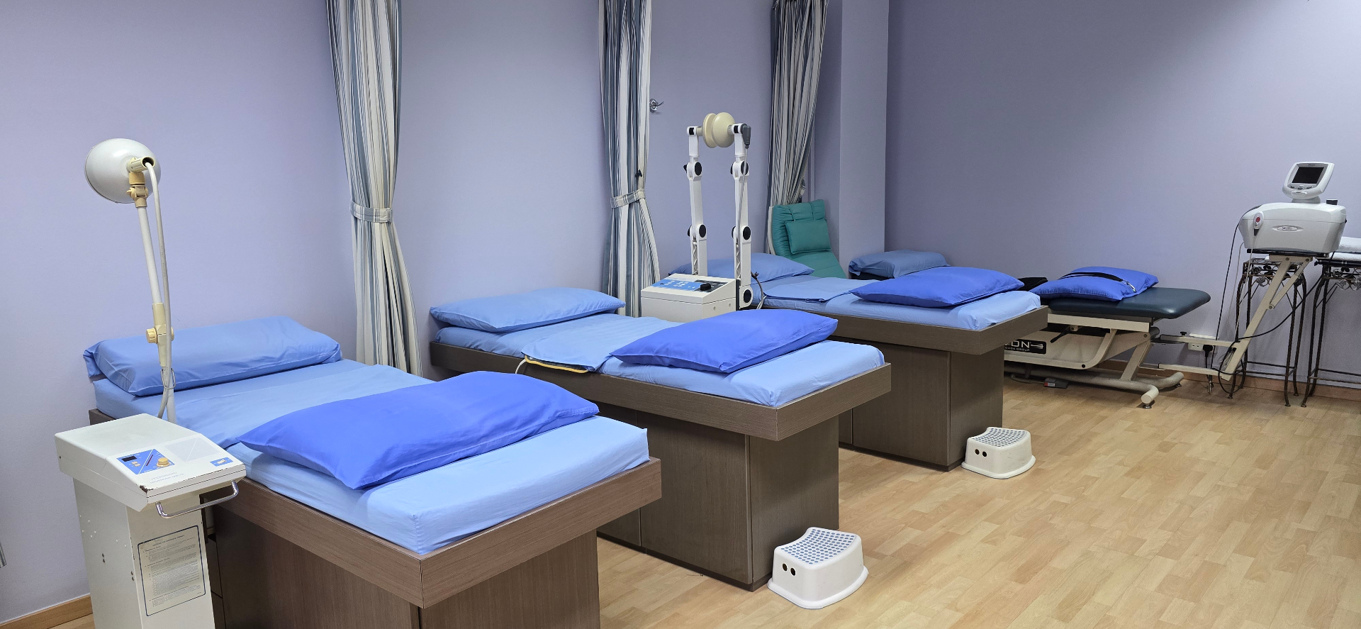 Calm physiotherapy treatment room with soft lavender walls
